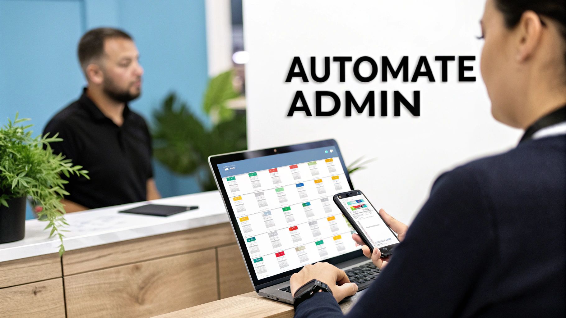 A person uses a laptop and smartphone displaying administrative software, with 'AUTOMATE ADMIN' on the wall, streamlining tasks.